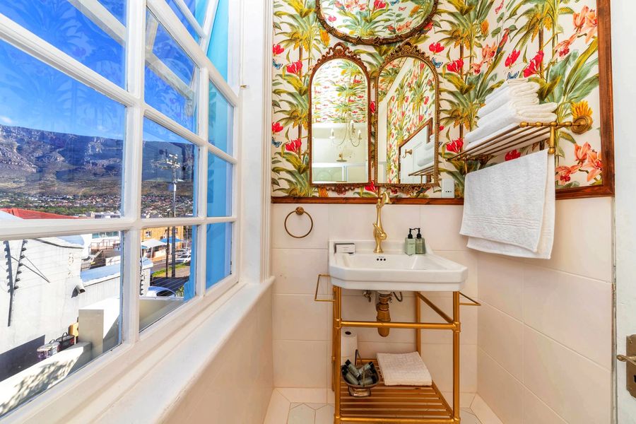 The bathroom with floral wallpaper and Table Mountain through the window