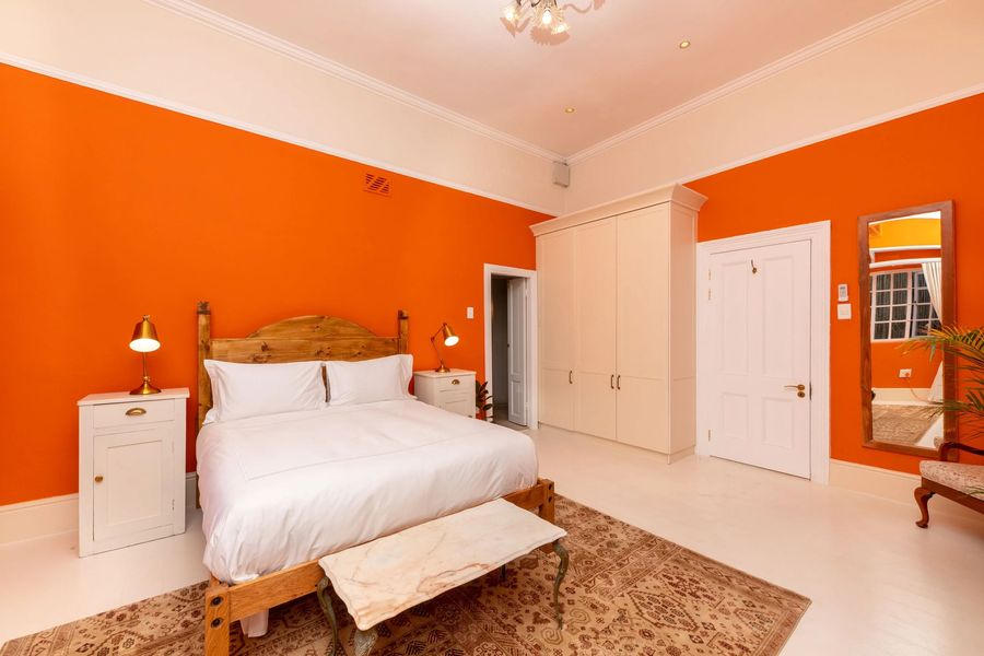 The orange room with a carved pine bed and a cream wardrobe