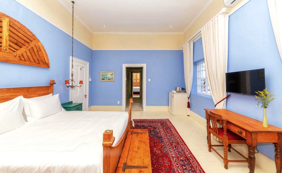 The blue room with a writing desk and a red Persian rug