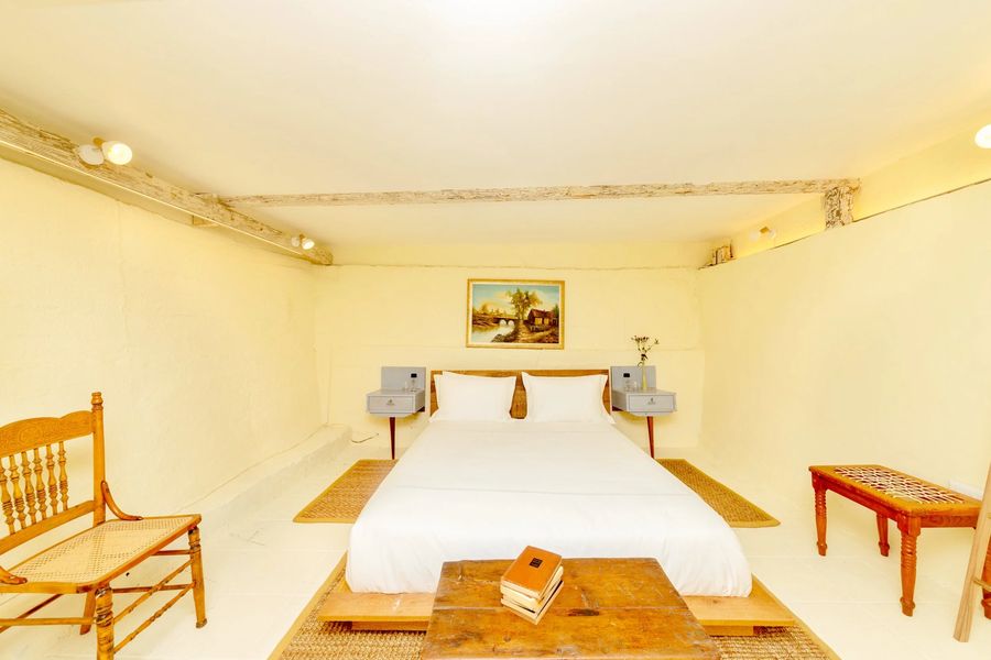 The bed with a wooden trunk at its foot