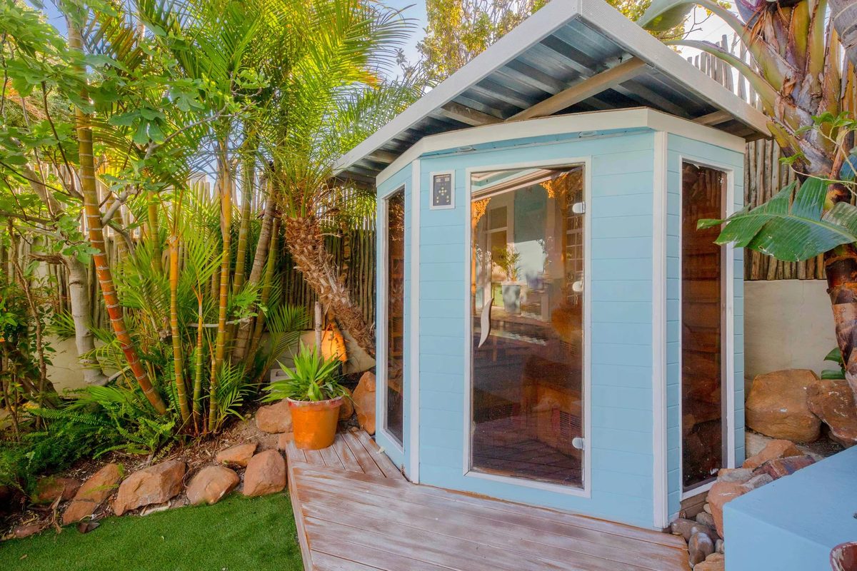 The infrared sauna cabin among palms in the garden